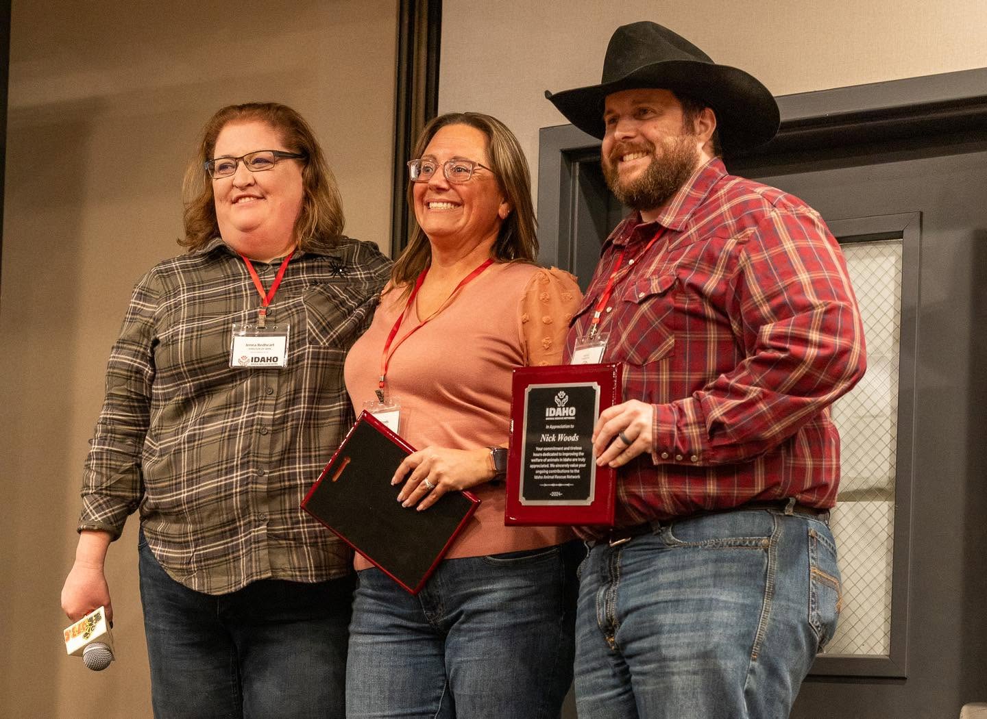 Three people posing with Pawtner Award plaques